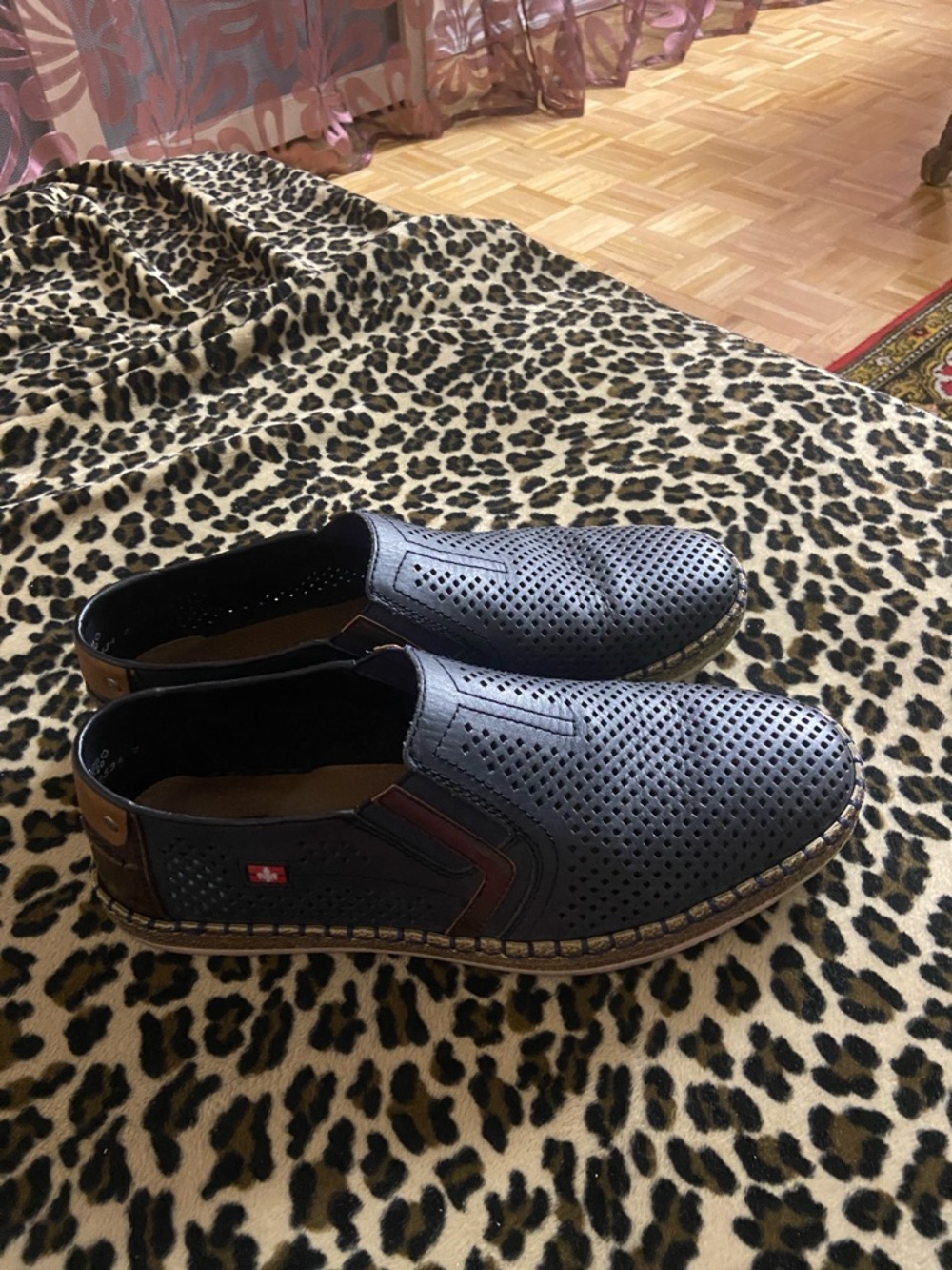 Rieker Black Perforated Slip-On Loafers with Brown Accents.